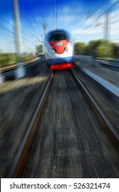 Amazing beautiful impressive front view on moving white red blue beautiful high speed passenger train. Motion blur. Moscow high speed trains rail tracks. Russian high speed train. Train in motion