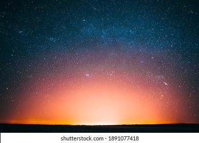 Amazing Beautiful Night Sky Glowing Stars Background Backdrop With Colorful Sky Gradient. Sunset Sunrise Light And Colourful Night Starry Sky In Blue Yellow Pink Orange Colors. Dark Ground Silhouette