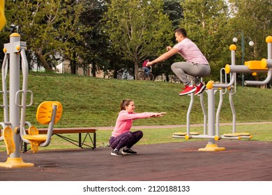 Amazing and beautiufl couple is doing some jumping exercise together in the park