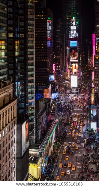 Amazing bird\'s eye view of Times Square, New York City\
at night showing all the car traffic and pedestrian activity in the\
center of the world. 