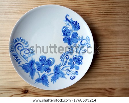 Amazing blue painting in folk style on the white plate