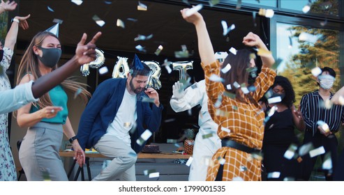 Amazing celebration party after Covid-19 quarantine ending. Friends dance in safety costumes under confetti slow motion.