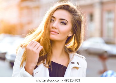 Amazing close up sunny sensual portrait of stunning elegant glamour sexy woman, posing at Europe street, sunny evening colors, perfect skin hairs and make up.