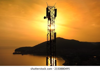 Amazing Closeup Sunset Drone View Of Silhouette Of Cell Tower. Wireless Connection. Spectacular View Of Cellular Tower With Mountains And Sea In The Background. 5G Network. ?ell Site