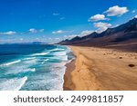 Amazing Cofete beach with endless horizon. Volcanic hills in the background and Atlantic Ocean. Cofete beach, Fuerteventura, Canary Islands, Spain. Playa de Cofete, Fuerteventura, Canary Islands.