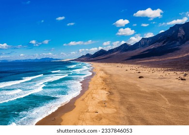 Amazing Cofete beach with endless horizon. Volcanic hills in the background and Atlantic Ocean. Cofete beach, Fuerteventura, Canary Islands, Spain. Playa de Cofete, Fuerteventura, Canary Islands. - Powered by Shutterstock