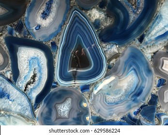 Amazing Colorful Blue Agate Crystal cross section background. Natural translucent slice geode crystal surface, Blue abstract structure slice mineral stone macro. Closeup of a banded Agate specimen