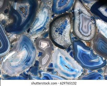 Amazing Colorful Blue Agate Crystal cross section background. Natural translucent slice geode crystal surface, Blue abstract structure slice mineral stone macro. Closeup of a banded Agate specimen
