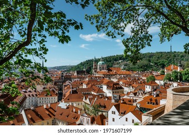 Amazing European cityscape.Spring view of old town with historical buildings,red roofs,St. Nicholas church,Petrin tower in Prague,Czech Republic.Sunny day in the city.Travel architecture concept