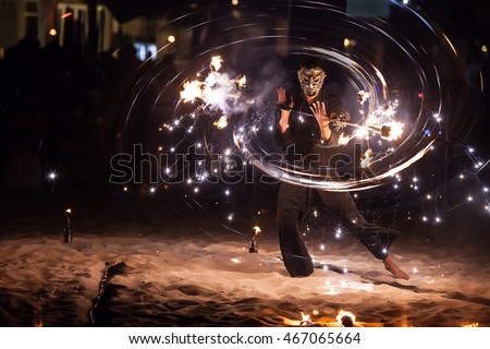 Amazing fire show with man in fancy Mask ,spin fire circle swing on the beach in full moon party in Thailand in Blur movement style 
