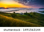 Amazing foggy sunrise over hills and a village from Bucovina Romania