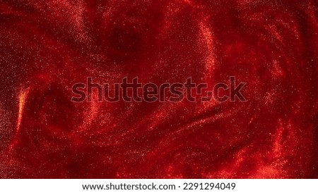 Amazing gold particles in red fluid. Sparkling glittering dust particles stains and overflows. Abstract liquid background with gold waves and red tints.