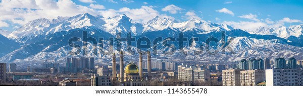 Amazing good day with clouds over the Almaty city\
near the Tian Shan mountains in winter. Best place for active life,\
vacation, hiking and trekking in Kazakhstan. Best view from the\
window.