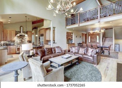 Magnífica casa de lujo con suave color de pared natural y suelo de madera clara, sala de estar de dos pisos con puente celeste y muebles de cuero.