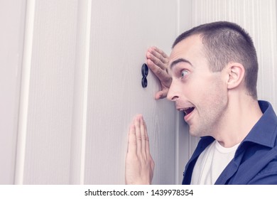 Amazing Guy Next To Front Door, Happy Man Looks Through The Peephole Of The Front Door, Portrait, Close Up, Toned