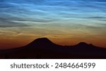 Amazing magical silver noctilucent clouds or night shining clouds NLCs above Czech Central Mountains