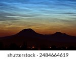 Amazing magical silver noctilucent clouds or night shining clouds NLCs above Czech Central Mountains