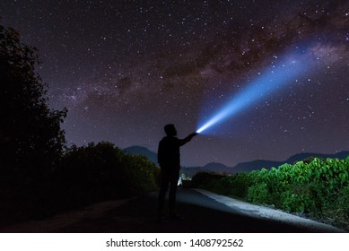 An Amazing Milky Way And Stargazing With A Silhouette Man Flashing The Light Towards The Stars.