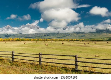 Amazing mountain landscape with cloudy sky, lath fence in the foreground and haystacks, Siberia, Irkutsk region, Russia - Shutterstock ID 1363037198