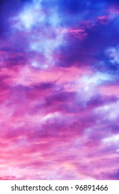 Amazing nature background: dramatic and moody pink, purple and blue cloudy sunset sky shot vertical.