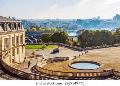 Amazing nature in the French garden (park)  of  Saint-Claude and Palace in Paris on a wonderful autumn day. Topiary trees are cones of small trees or shrubs. Bicycle people and car moving - Powered by Shutterstock