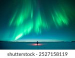 Amazing night landscape with Polar lights. Northern lights in winter field. Tourist with red flashlight standing on snowy field against the backdrop of incredible starry sky with Aurora borealis