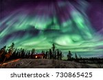 Amazing Northen Lights in purple and blue color dancing over chalet in Yellowknife