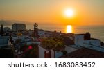 Amazing Orange Sunset Over Blue Ocean on a Rooftop view of Old Town in Puerto Vallarta Mexico