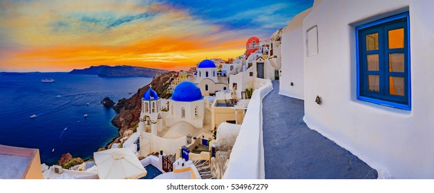 Amazing panorama sunset view with white houses in Oia village on Santorini island in Greece.