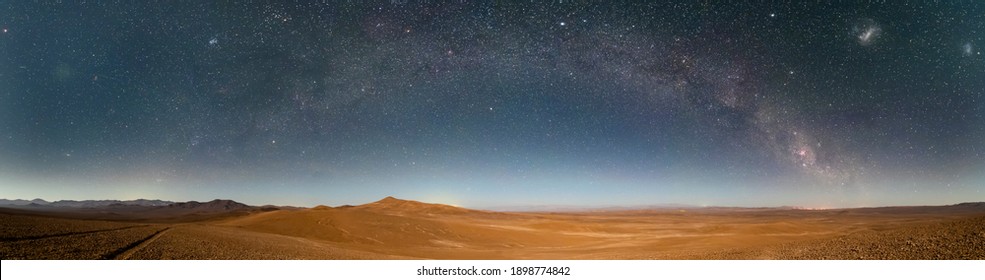 An amazing panoramic view of the Milky Way above Atacama Desert vast sand fields. An awe night sky view with our galaxy arm creating an arch in between the stars. An idyllic and motivational scenery - Powered by Shutterstock