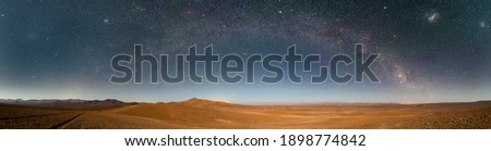 An amazing panoramic view of the Milky Way above Atacama Desert vast sand fields. An awe night sky view with our galaxy arm creating an arch in between the stars. An idyllic and motivational scenery