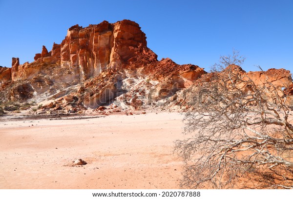 Amazing Rainbow Valley in Northern\
Territory, Australia, just outisde Alice Springs.  Beautiful red\
and orange rock formation with blue sky and orange\
sands