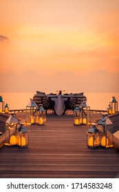 Amazing Romantic Dinner On The Beach On Wooden Deck With Candles Under Sunset Sky. Romance And Love, Luxury Destination Dinning, Exotic Table Setup With Sea View