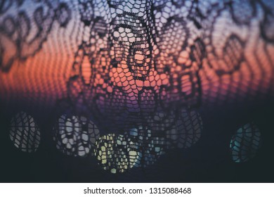 Amazing romantic sunset in window behind silhouettes of tulle texture. Wonderful pink violet blue dawn sky from window through patterned curtain. Cosiness background of scenic sunrise. Copy space. - Powered by Shutterstock