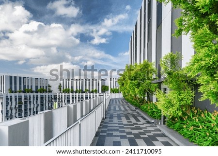 Amazing rooftop garden. Scenic outside terrace with park and beautiful city view. Modern benches under green trees along walkway. Urban eco design and mini-ecosystem. Landscaping in Singapore.
