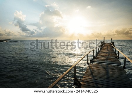 Amazing sandy tropical beach with silhouette wooden bridge out of the beach tropical  Boardwalk or Wooden walkway to the horizon on sea ocean paradise landscape , sunrise or sunset sea dramatic sky