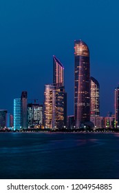 Amazing Scene Of Abu Dhabi Skyline At Night. Colorful Buildings. 