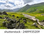 Amazing scenery of the view on Kyzylkol river and Emmanuel glade with camping in the Elbrus region with the huge spotted stones on the foreground. Prielbrusye, North Caucasus, Russia.