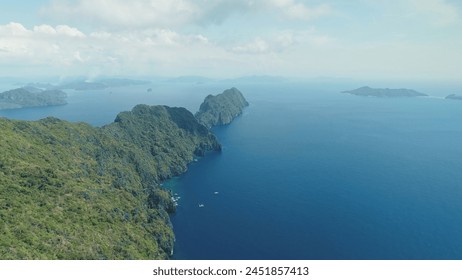 Amazing seascape of sea bay with rocks beach. Mountain island with green tropical forest at cliff ocean shore. Boats, vessels at blue coast water of El Nido Isles, Philippines, Visayas Archipelago - Powered by Shutterstock