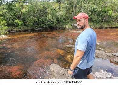 Amazing Sights Of Colombia-Caño Cristales (English: Crystal Channel). Tourist Looks Disappointed At The River With Red Algae (real Color Without Filters)