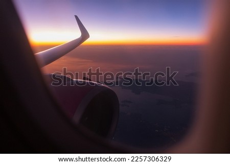 Amazing skyscape view in the sky with sunset, European continent, wing and turbine from porthole. Beautiful views from the plane. Traveling by airplane at night.