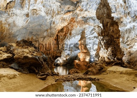 Amazing stalagmite reflected in water inside Phong Nha Cave at Phong Nha-Ke Bang National Park in Vietnam. Phong Nha Cave is a popular tourist attraction of Asia.