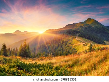Amazing summer sunrise in Carpathian mountains. Colorful morning scene with first sunlight glowing hills and valleys. Beauty of nature concept background. Artistic style post processed photo.