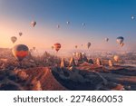 Amazing sunrise landscape in Cappadocia with colorful hot air balloon fly in sky over deep canyons, valleys. Turkey banner travel Concept.