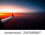 Amazing sunrise seen from an airplane window. Dark background of travel or holiday.