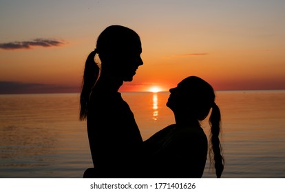 Amazing Sunset. Couple Siluett On The Sunset Background. People On The Image - Unrecognizable.Orange Sunset - Golden Hour During Estonian Mid Summer Fest. Darker Images With High Resolution