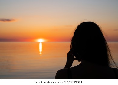 Amazing Sunset. Female Siluet On The Sunset Background. Model Taking Image Of The Sunset. People On The Image - Unrecognizable.  Orange Sunset - Golden Hour During Estonian Mid Summer Fest.