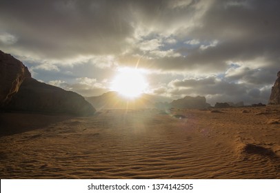 Amazing sunset at the Jordanian desert of Wadi Rum ,this breathtaking sunset will really blow your mind. Its stunning to see how the sun disappearing slowly behind those iconic mountains. - Shutterstock ID 1374142505