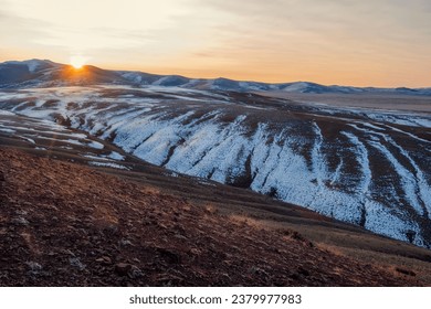 Amazing sunset over the autumn snow-capped mountains in the Kokorya tract in the Altai Republic, such wanderlust. Mountain ice peaks of Siberia and sunny sky of Altai background.