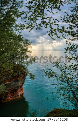 Amazing sunset with sun rays shining down beyond Sea Caves in Apostle Islands Maritime Cliffs State Natural Area overlooking Lake Superior, Bayfield, Wisconsin